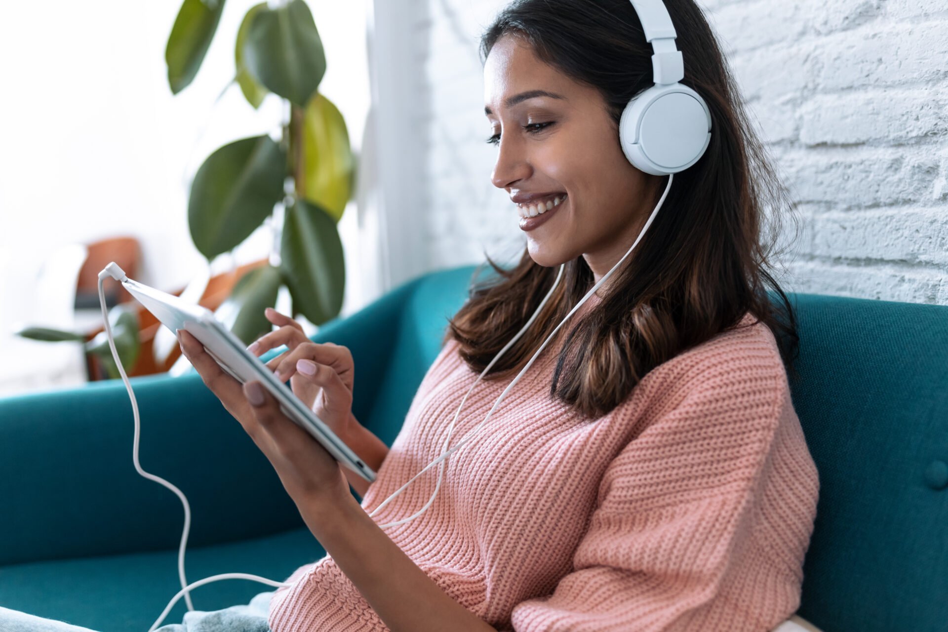 Young women listening to music while on sofa