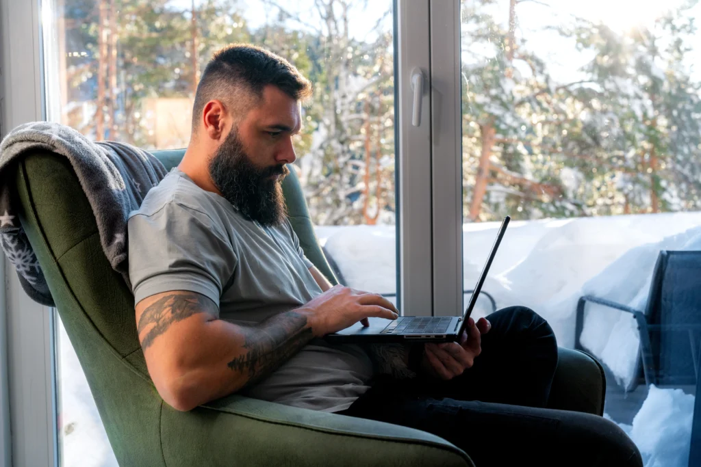 a man sitting in a chair with a laptop