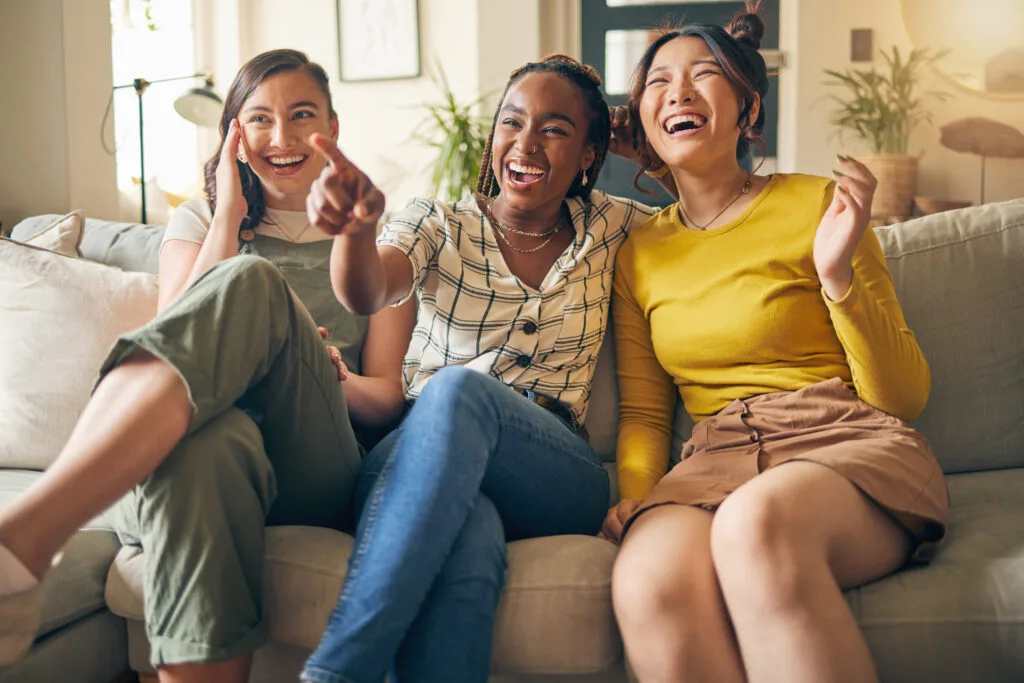 a group of women sitting on a couch laughing