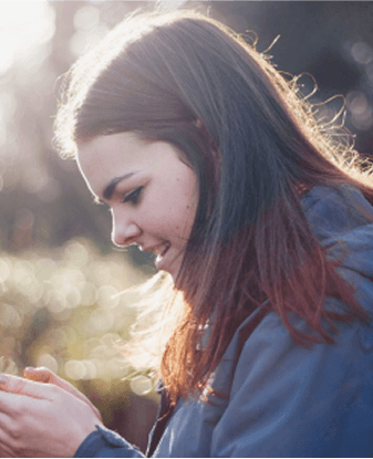 a woman smiling at her phone